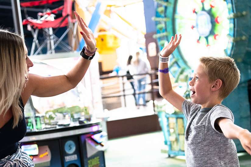 Mother and son high-fiving in Tom Foolerys Adventure Park.
