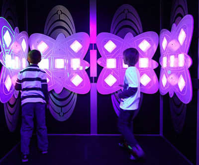 two kids playing with an interactive light game