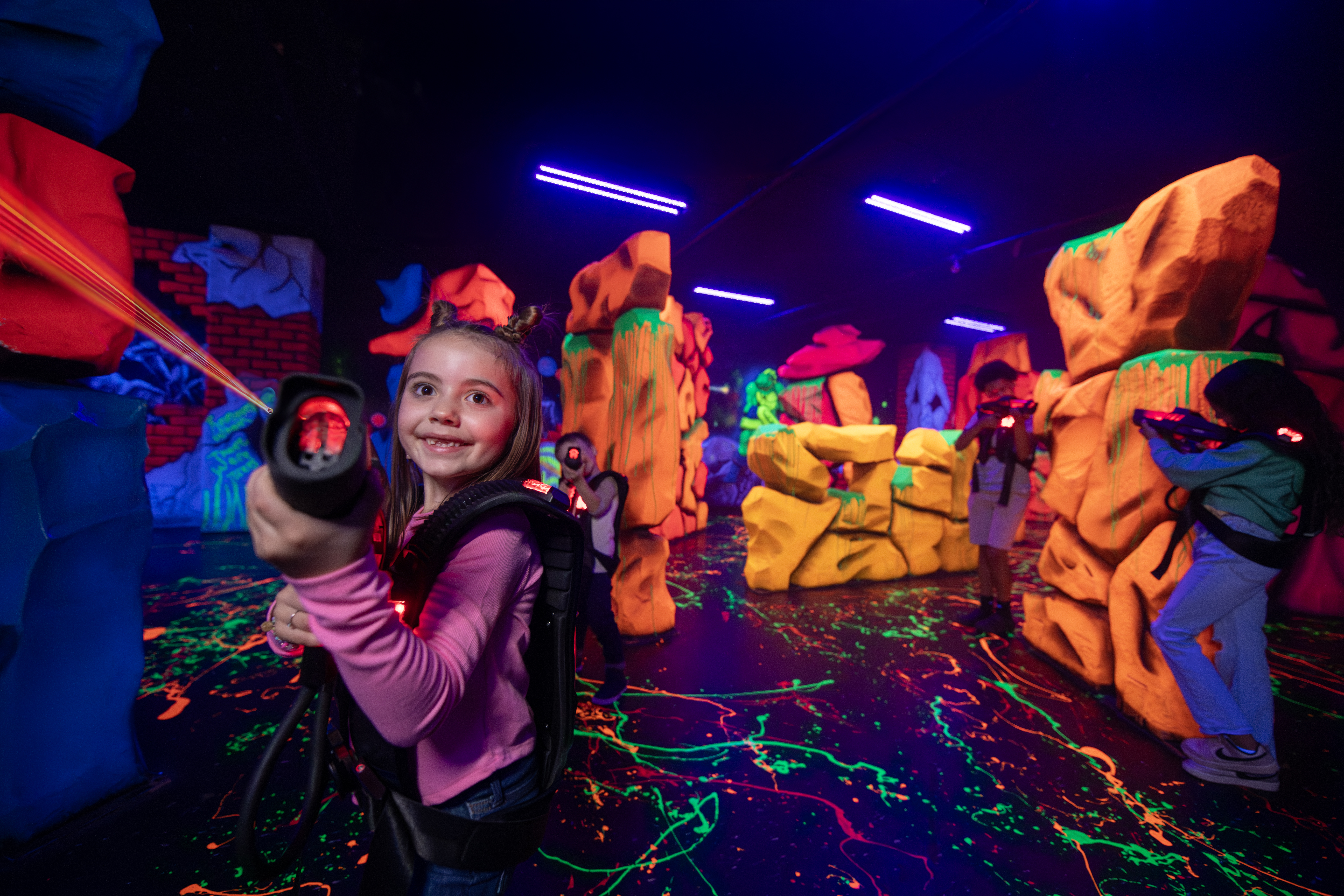 Girl playing laser tag with neon background
